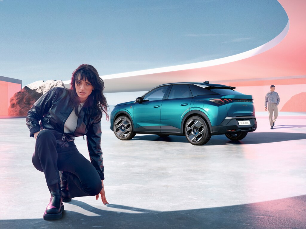 Mulher ajoelhada ao lado do novo PEUGEOT 3008 PLUG-IN HYBRID com vista traseira