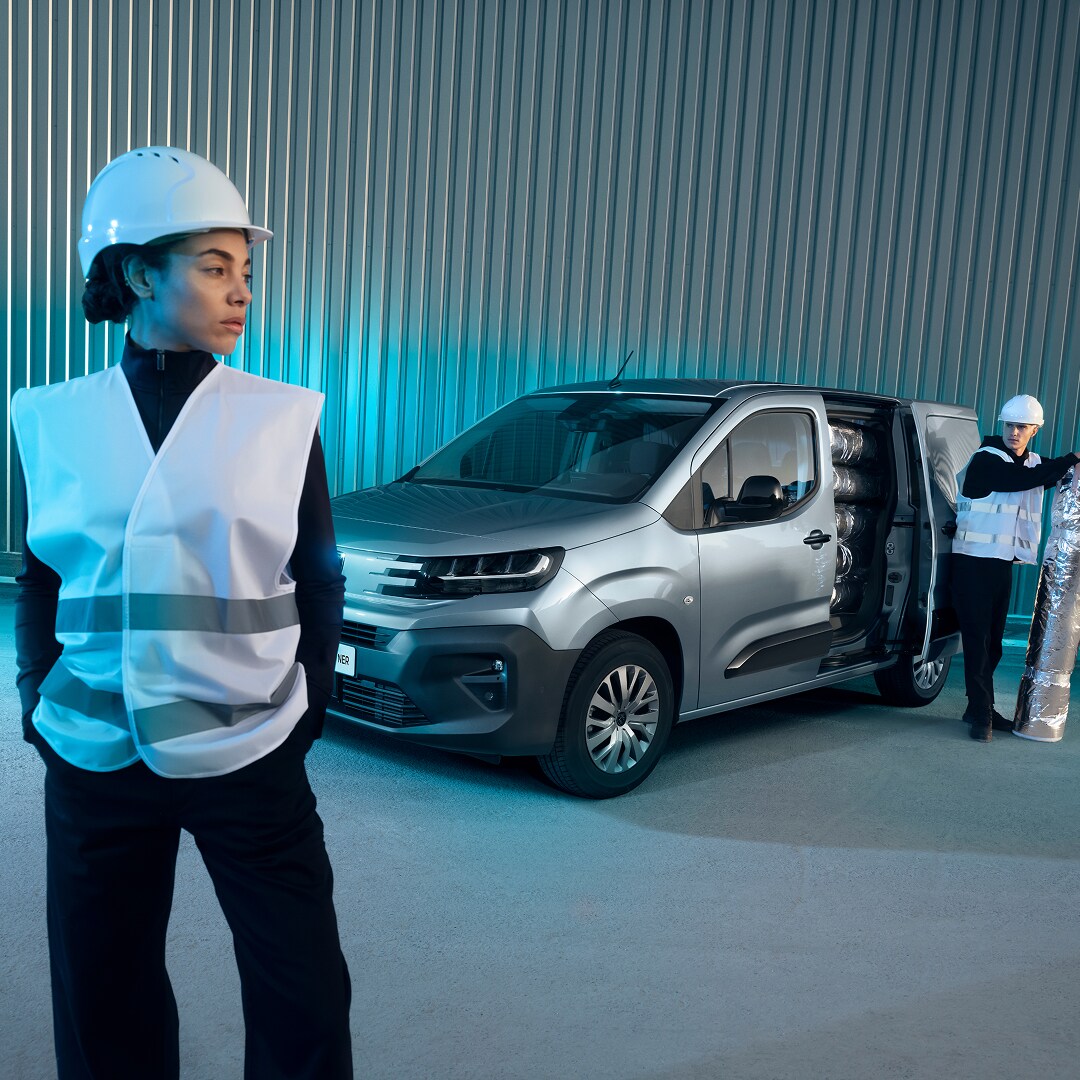 Mulher em pé em frente um PEUGEOT Partner